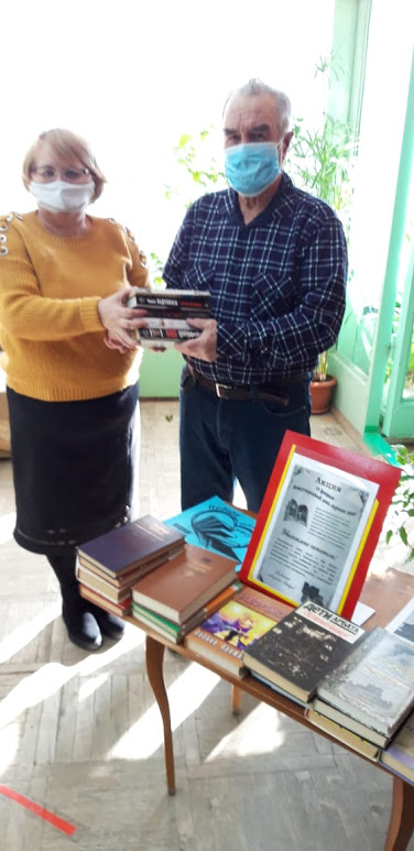 Читатель и библиотекерь держат стопку книг