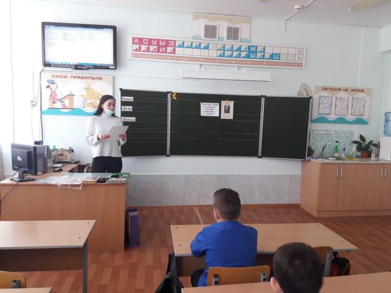Девушка стоит перед классом  вшколе