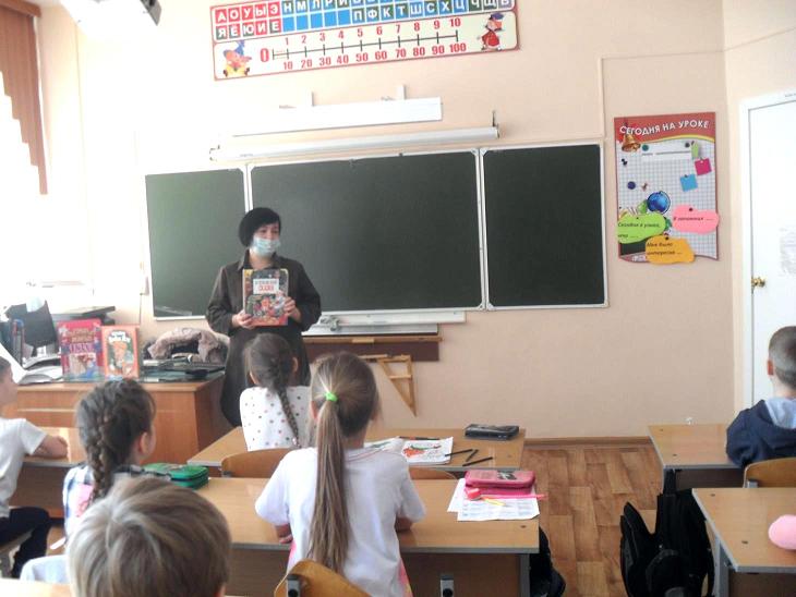 Библиотекарь стоит перед классом и расссказывает о книге