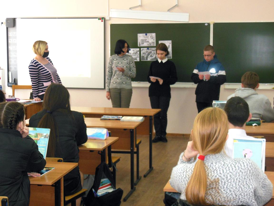 Библоитекарь и школьники стоят у доски.