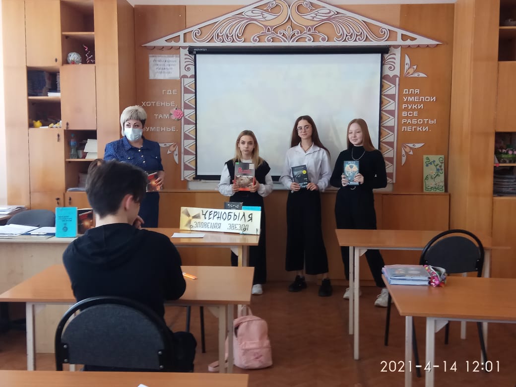 Девочки и бибилотекарь стоят у доски в классе. В руках  у девочек книги 