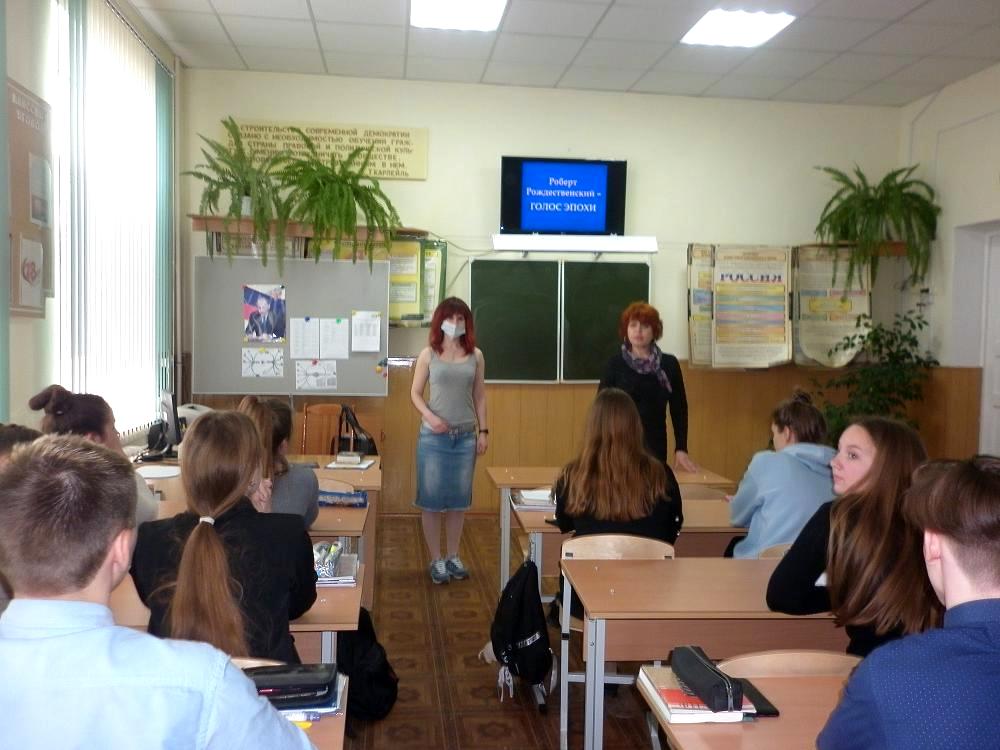 Девушка и учитель стоят перед классом.