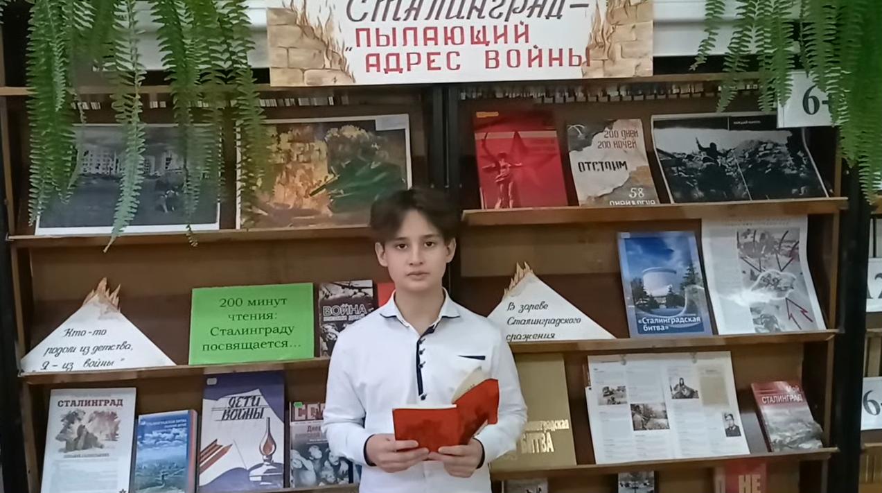 мальчик читает книгу в библиотеке