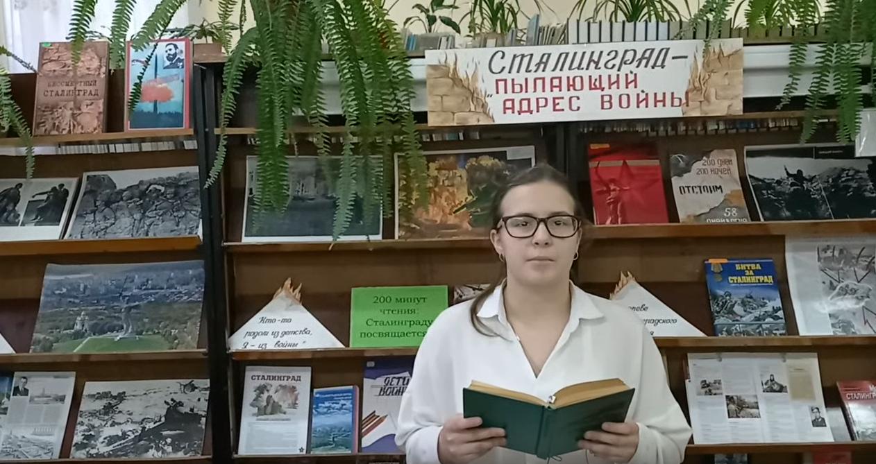 девушка читает книгу в библиотеке