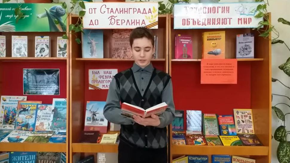 мальчик на фоне книжной выставки читает книгу 