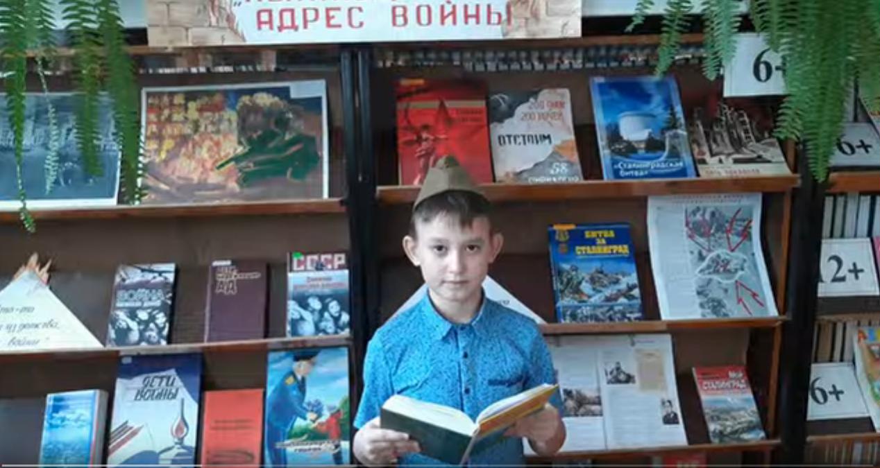 мальчик в пилотке  читает книгу в библиотеке