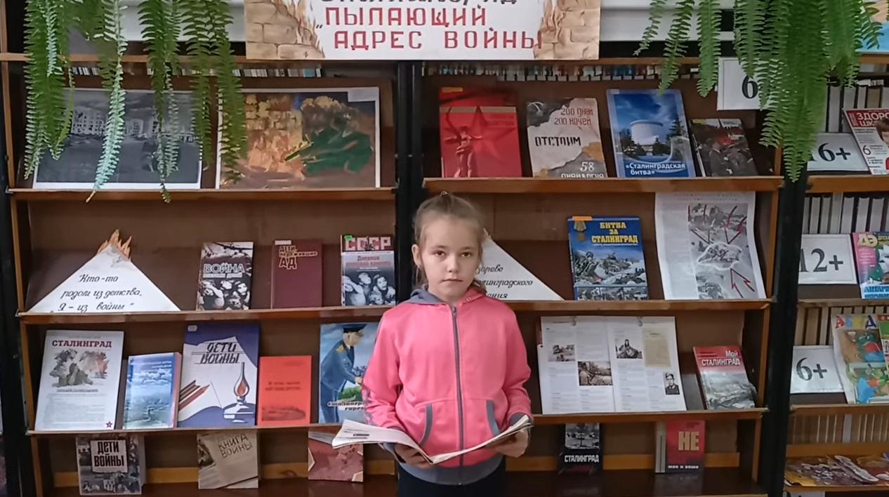 девочка в библиотеке читает книгу