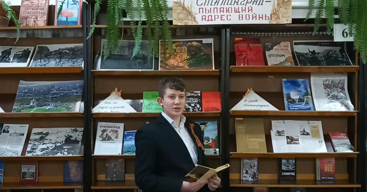 подросток читает кни гу в библиотеке