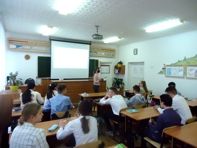Перед школьниками вклассе стоит девушка
