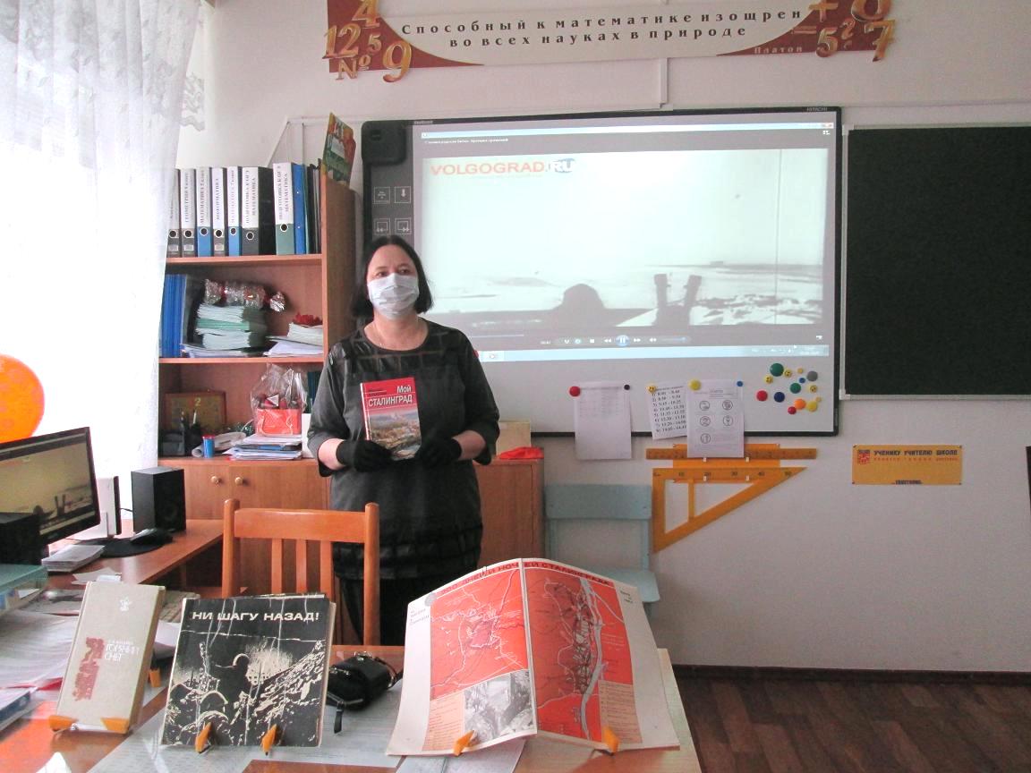 Библиотекарь на фоне кадров хроники  рассказывает в классе о Сталинградской битве. 